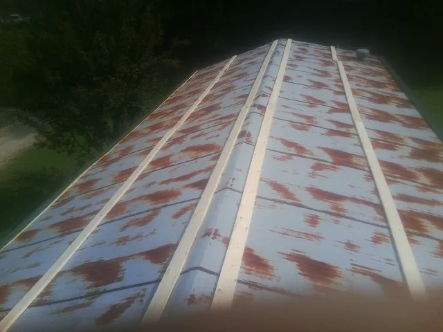 Rusted metal roof panels with new wood purlins before replacement — Storm Damage Roof Repair in Northford by Roofing Brothers