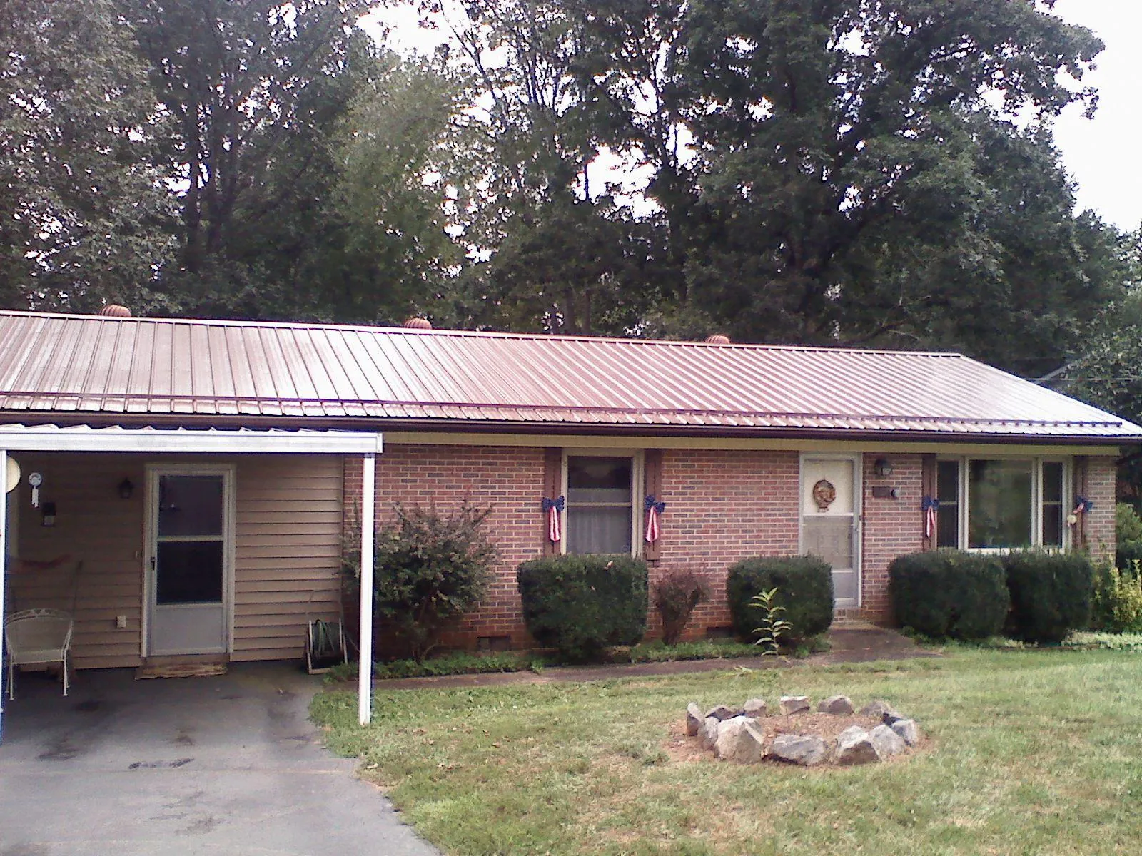 Bronze metal roof and carport on a brick ranch home — Roof Repair work by our crew in Northford